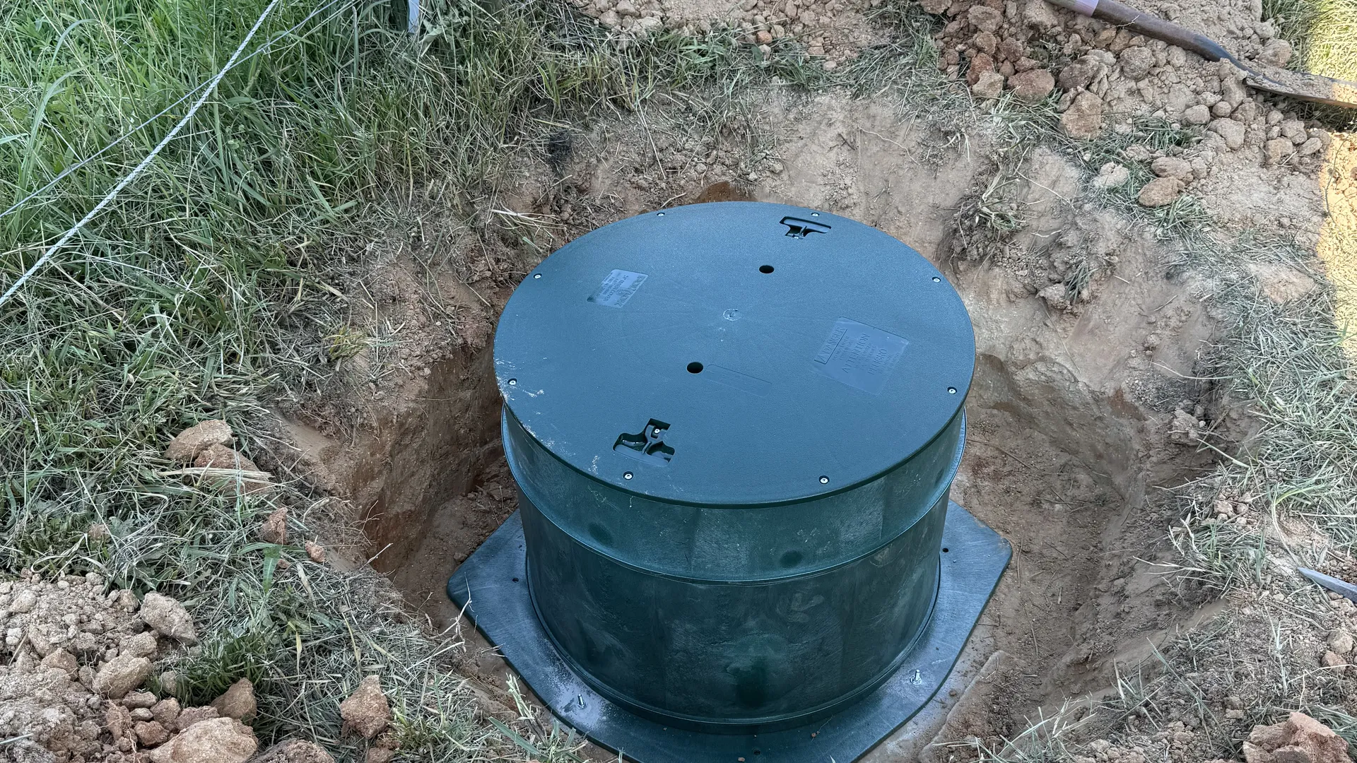 Finished septic riser in a small excavation before backfill