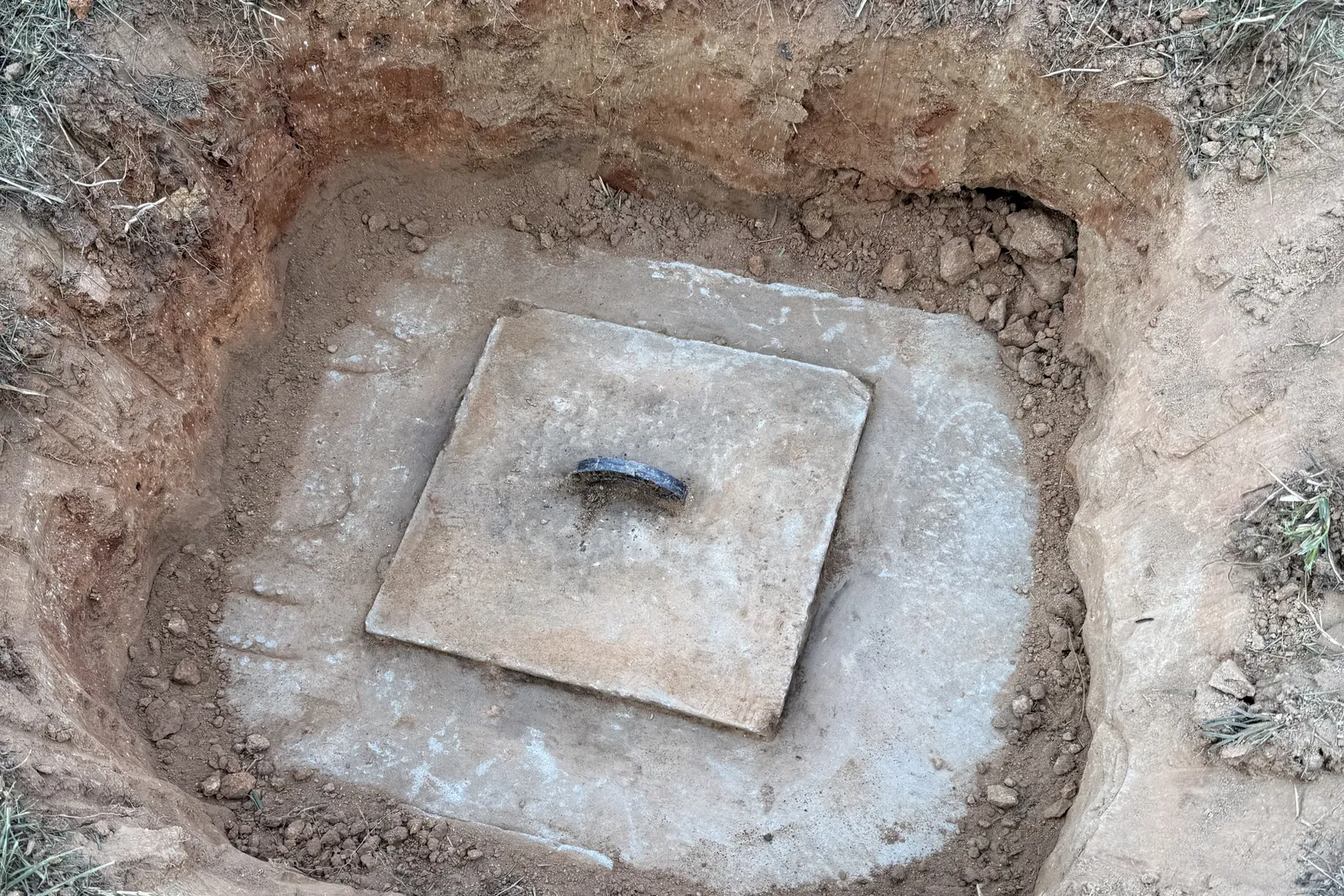 Concrete septic tank access lid uncovered for an inspection