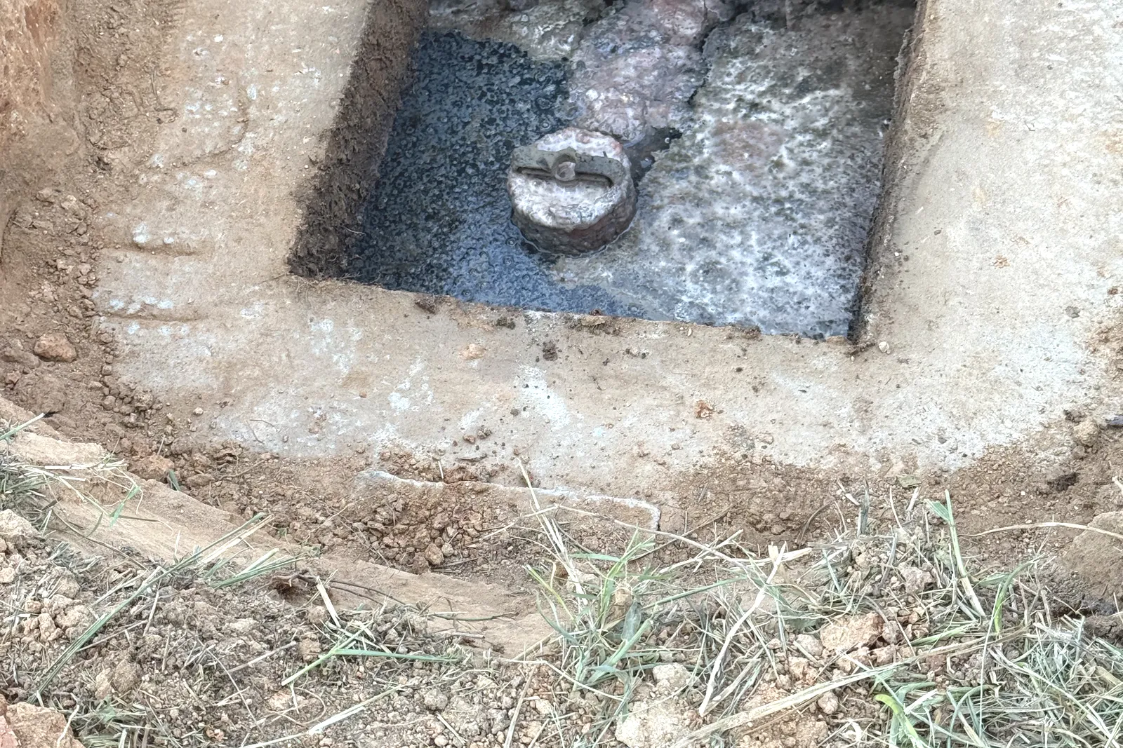 Septic tank outlet chamber showing sludge and scum during an inspection